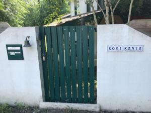 une porte verte avec un panneau sur un mur blanc dans l'établissement Belle Villa basque avec piscine et jardin de 3000m2, à Saint-Jean-de-Luz