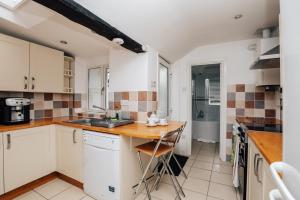 a kitchen with white cabinets and a wooden counter top at Park End House - Parking, Pet Friendly in Henley on Thames