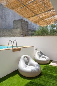 two white beanbags sitting on the grass next to a pool at Villa Franitu - Corsano in Corsano
