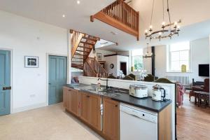 a kitchen with a counter top and a living room at Converted Chapel, Stunning Sea & Mountain Views! in Penmaen-mawr