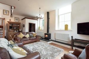 a living room with a couch and a fireplace at Converted Chapel, Stunning Sea & Mountain Views! in Penmaen-mawr