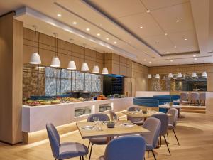 um restaurante com mesas e cadeiras e uma cozinha em Two MacDonnell Road em Hong Kong