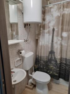 ein Badezimmer mit einem WC und einem Duschvorhang mit dem Eiffelturm in der Unterkunft Apartments Peričić in Podstrana