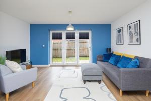 una sala de estar con 2 sofás y una pared azul en Derby Train Station Roof Terrace House en Derby