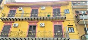 ein gelbes Gebäude mit Balkon an der Seite in der Unterkunft ALLOGGIO DEI MILLE in Palermo
