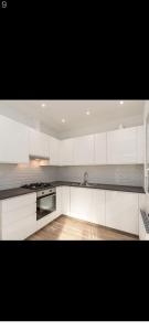 a kitchen with white cabinets and a stove top oven at Enjoy a private room in the center of Antwerpen in Antwerp