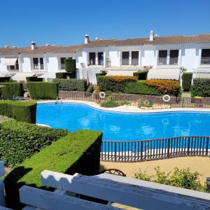 a swimming pool in front of a building at Mi casita playera in El Rompido