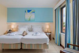 ポルト・サントにあるPestana Porto Santo Premium All Inclusive Beach & SPA Resortのベッド2台と窓のある寝室 +37枚の写真