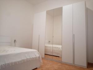 ein weißes Schlafzimmer mit weißen Schränken und einem Bett in der Unterkunft The Holiday Family in Veglie