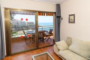 a living room with a couch and a balcony at Rentalmar Salou Mar in Salou