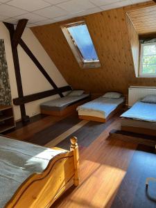 a attic room with two beds and two windows at Hostel BAZA 15 in Wrocław