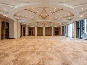 an empty ballroom with a large room with a ceiling at Alwadi Hotel Doha - MGallery in Doha