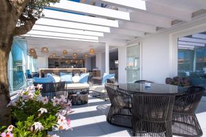 d'une terrasse avec des chaises en osier et une table. dans l'établissement Best Western Hotel Blumarea, à Castelsardo