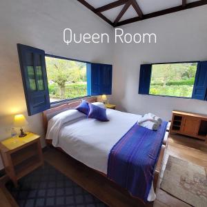 1 dormitorio con cama blanca y almohadas azules en Reserva Guadalajara - Cocora Valley, en Salento