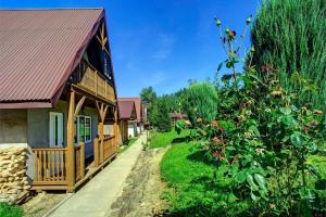 a house with a red roof next to a garden at Zajazd pod Sosnami in Berezka