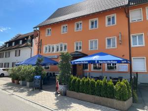a building with umbrellas and tables in front of it at Landgasthof Ochsen in Wutöschingen
