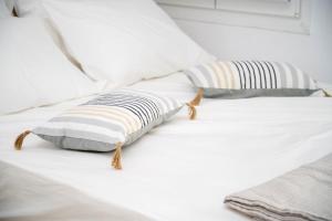 - un lit blanc avec 2 oreillers dans l'établissement "Calm Joy & J" - Calm, à Ermoúpoli