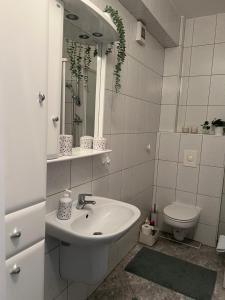 a white bathroom with a sink and a toilet at Apartament Przy Kawczej in Międzyzdroje