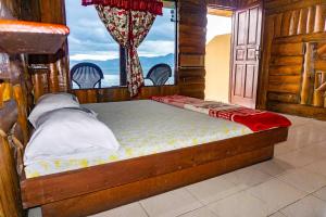 a bed in a room with a window at Reggae Guest House in Tuk Tuk