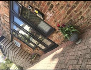 a brick building with a window and a potted plant at Aiskew Villa Annex in Bedale