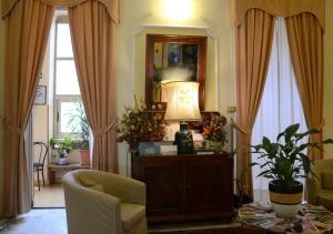 a living room with a lamp and two windows at Hotel Eden in Turin