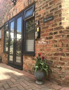 a brick building with a flower pot in front of it at Aiskew Villa Annex in Bedale