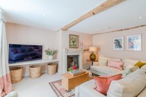 a living room with a fireplace and a tv at Merchant House in Charlbury