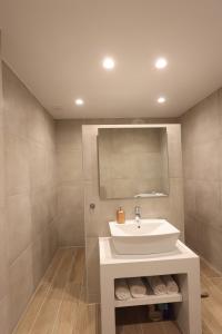 a bathroom with a white sink and a mirror at Captain's Pounda Suite in Apróvaton