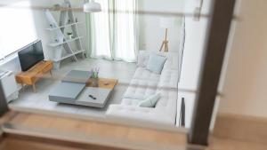 ein Wohnzimmer mit einem weißen Sofa und einem Tisch in der Unterkunft A brand new, beautifully decorated maisonette. in Chalkida