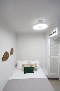 a white bedroom with a large white bed with pillows at Captain's Pounda Suite in Apróvaton