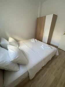 a bed with white sheets and pillows in a room at Le Plaza in Thessaloniki