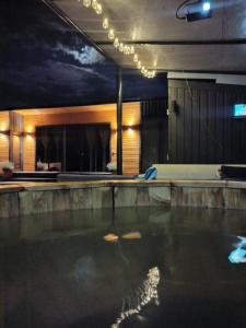 una piscina de agua en una habitación por la noche en Stablo guest house, en Bărăşti