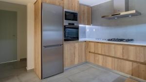 una nevera de acero inoxidable en una cocina con armarios de madera en A brand new, beautifully decorated maisonette. en Chalkida