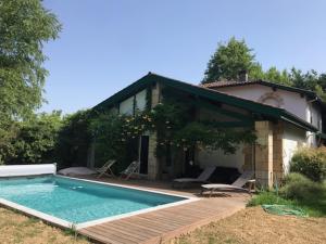 une maison avec une piscine en face d'une maison dans l'établissement Belle Villa basque avec piscine et jardin de 3000m2, à Saint-Jean-de-Luz