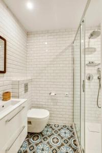 a bathroom with a toilet and a sink and a shower at Central & Stylish renovated Parisian apt / 6-8 guests in Paris