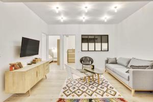 a living room with a couch and a tv at Central & Stylish renovated Parisian apt / 6-8 guests in Paris