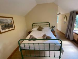 a bedroom with a green metal bed in a room at Orchard Cabin Herefordshire Wye Valley in Ross on Wye +3 photos