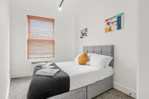 a bedroom with a bed with white sheets and a window at Roof terrace 2BED Property CAMDEN free WiFi in London