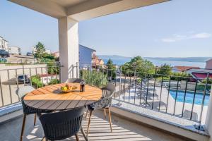 een tafel op een balkon met uitzicht op een zwembad bij Apartment House Vista in Crikvenica