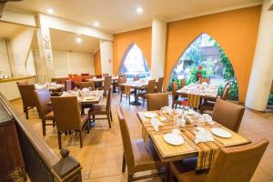 卡蘭古特的住宿－印度尼蘭斯大飯店，用餐室设有桌椅和窗户。
