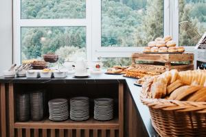 a breakfast buffet with bread and pastries on a counter at Resort Dlouhé Stráně in Loučná nad Desnou