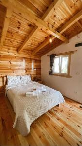 ein Schlafzimmer mit einem Bett in einem Holzzimmer in der Unterkunft Organic Family Farm in Žabljak
