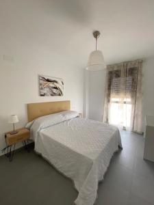ein weißes Schlafzimmer mit einem Bett und einem Fenster in der Unterkunft piso recinto ferial en teatinos in Málaga