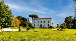 een wit gebouw in het midden van een veld bij Villa Archi in Faenza