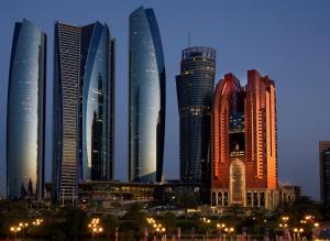 un groupe de grands bâtiments dans une ville la nuit dans l'établissement Bab Al Qasr Hotel, à Abu Dhabi