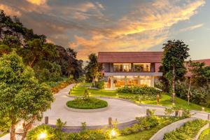 una casa con un jardín delante de ella en Aurika, Coorg - Luxury by Lemon Tree Hotels, en Madikeri