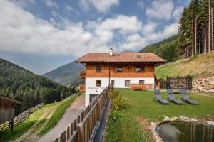 una casa en una colina con sillas delante en Pfattenspitz Maurerhof, en Valdurna