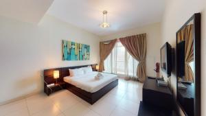 a bedroom with a bed and a television in it at Key View - Marina Sail in Dubai