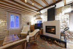 a living room with a fireplace and a table at Maison du Passeur du XVIII siècle Authenticité et Confort avec Jardin et SPA pour un séjour de qualité in Pressagny l'Orgueilleux