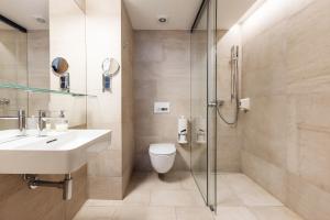 OREA Hotel Arigone Olomouc في أولوموك: حمام مع مرحاض ومغسلة ودش